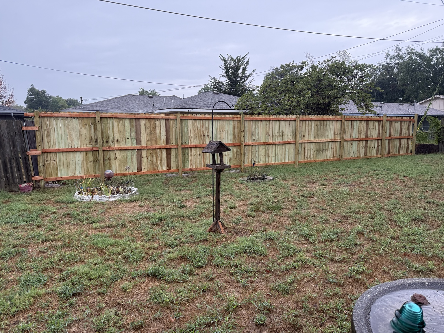Completed wood privacy fence across a backyard