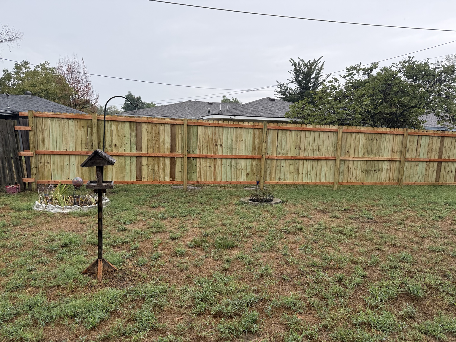 Long completed fence line viewed across lawn