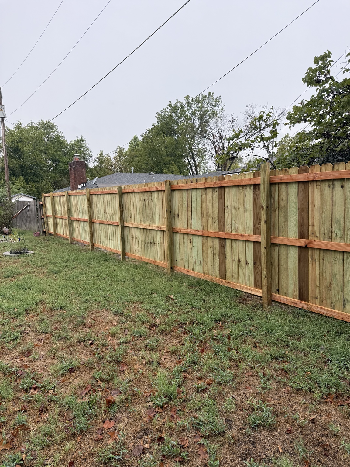 Fence installation in progress with rails being leveled