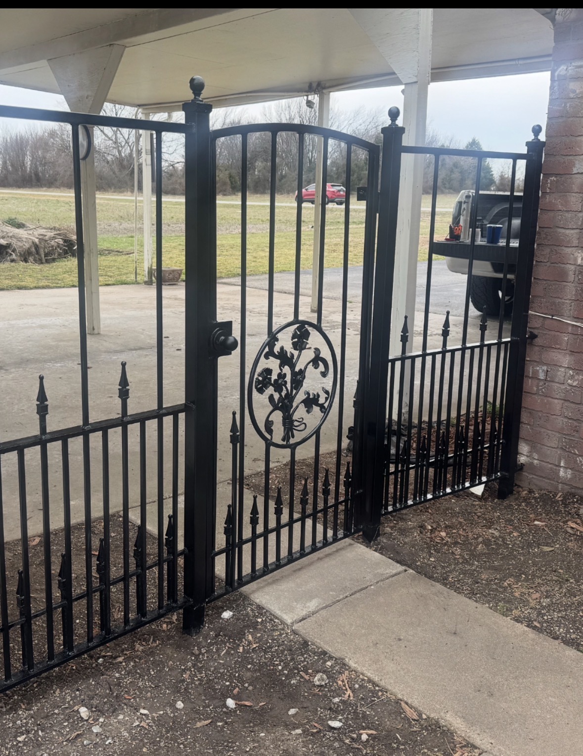 Custom black ornamental steel entry gate by Bradshaw Gates