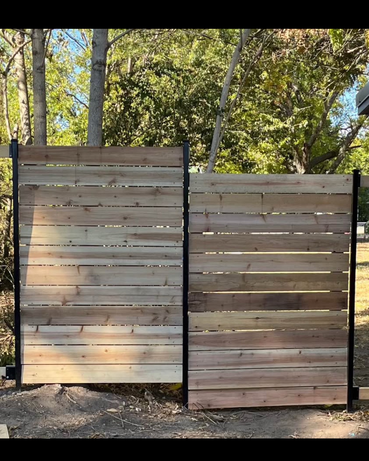 Steel framed fence panels with horizontal wood boards